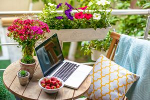 Beautiful terrace or balcony with small table, chair and flowers. Toned image